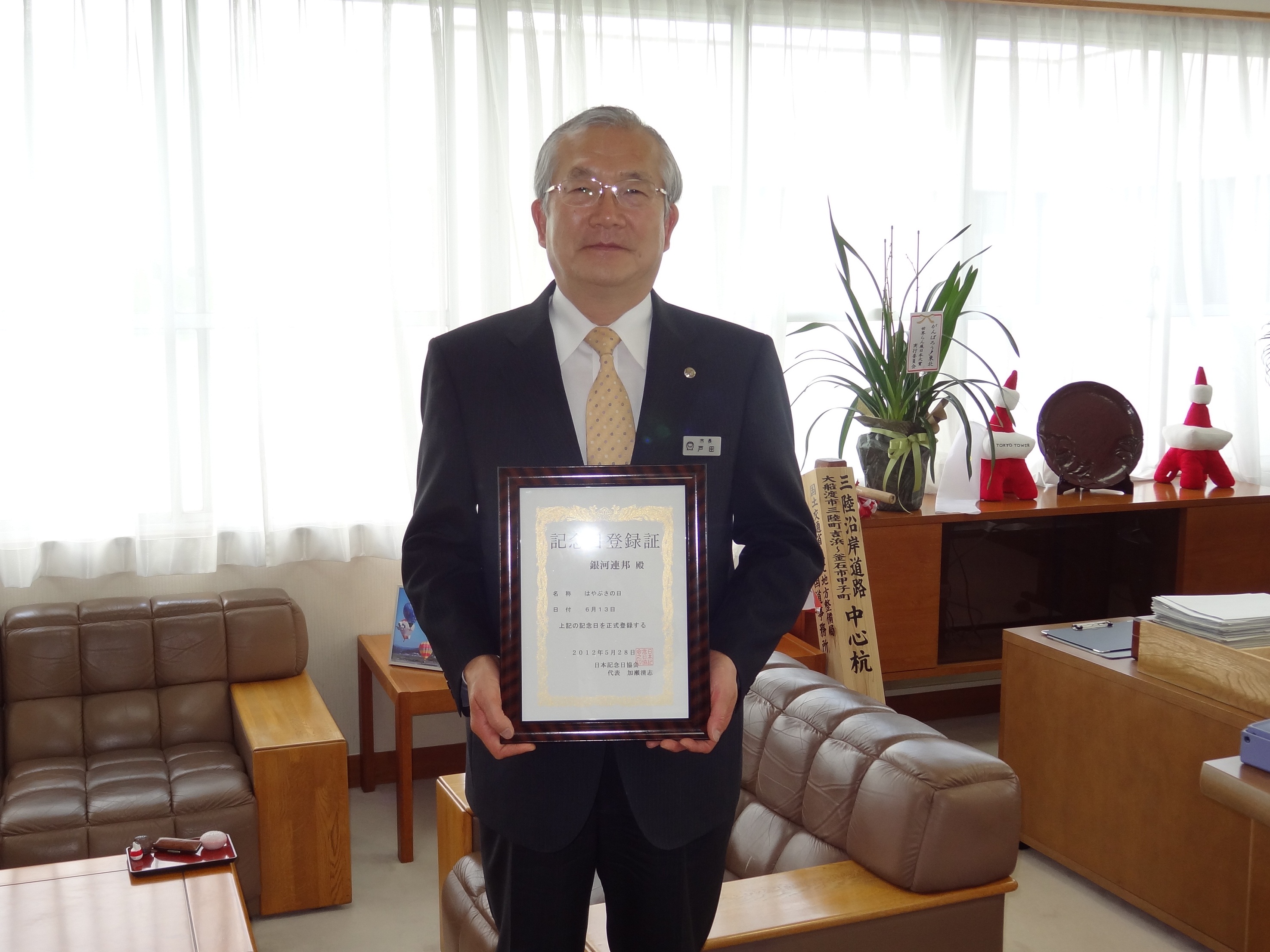 戸田公明大船渡市長が記念日登録証を持っている写真