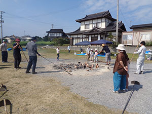完成した土器を灰の中から取り出す様子